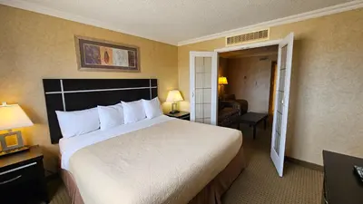 a bedroom with a large bed in a hotel room at The George Dawson Inn & Conference Centre in Dawson Creek