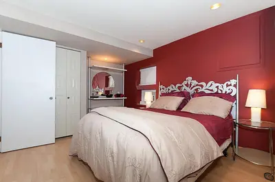 a bedroom with a large bed with red walls at House On Dunbar B&B in Vancouver