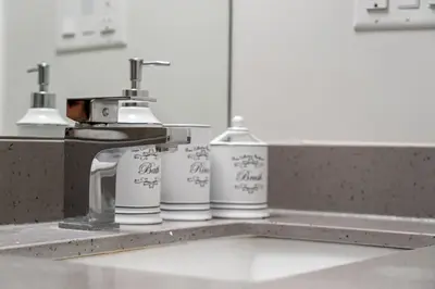a kitchen counter with three bottles sitting next to a sink at ELEMENT ON FIRST by Manna in Calgary