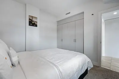 a white bedroom with a large bed and a closet at ELEMENT ON FIRST by Manna in Calgary