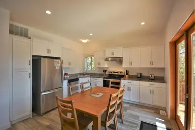 a kitchen with a wooden table and a refrigerator at Pender Harbour Resort & Marina in Garden Bay