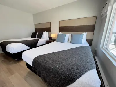 a hotel room with two beds and a window at Oceanside Villas in Sechelt
