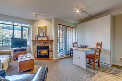 a living room with a couch and a fireplace at Town Plaza Suites by Golden Dreams in Whistler