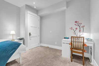 a bedroom with a bed and a chair and a desk at Vancouver West Cozy Retreat by Host Launch in Vancouver