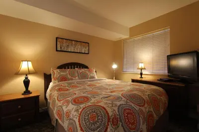 a bedroom with a bed and a flat screen tv at Marketplace Lodge by Whistler Retreats in Whistler