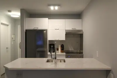 a kitchen with white cabinets and a counter top at Marketplace Lodge by Whistler Retreats in Whistler