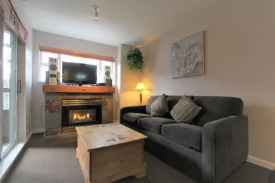 a living room with a couch and a fireplace at Marketplace Lodge by Whistler Retreats in Whistler