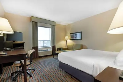 a hotel room with a bed and a desk and a computer at Best Western Pacific Inn in Vernon