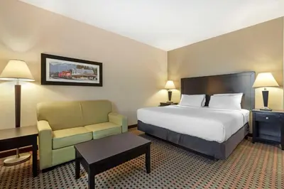 a hotel room with a bed and a chair at Best Western Pacific Inn in Vernon