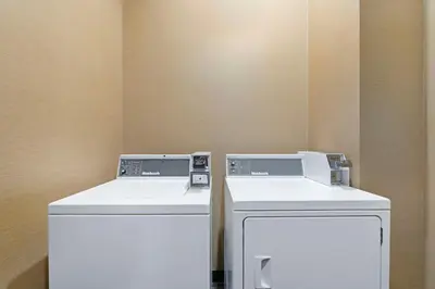 two washing machines and a washer and dryer in a room at Best Western Pacific Inn in Vernon