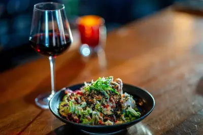 a bowl of food next to a glass of wine at Residence Inn by Marriott Calgary Downtown/Beltline District in Calgary
