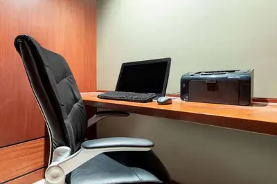 a desk with a laptop computer and a printer at Ramada by Wyndham Northern Grand Hotel & Conference Centre in Fort Saint John