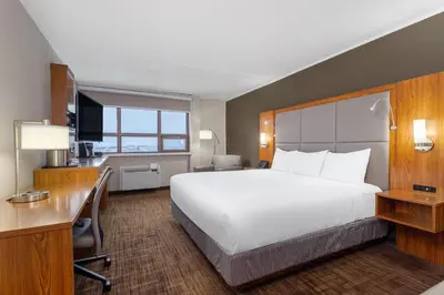 a hotel room with a large bed and a desk at Ramada by Wyndham Northern Grand Hotel & Conference Centre in Fort Saint John