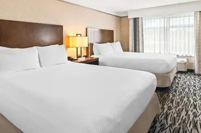 a hotel room with two beds and a window at Best Western Plus Pitt Meadows Inn & Suites in Pitt Meadows