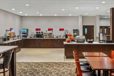 a restaurant with a counter and a table and chairs at Best Western Plus Pitt Meadows Inn & Suites in Pitt Meadows