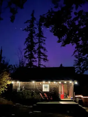 a cabin lit up at night with lights on it at Morning Star Cabin in Nelson