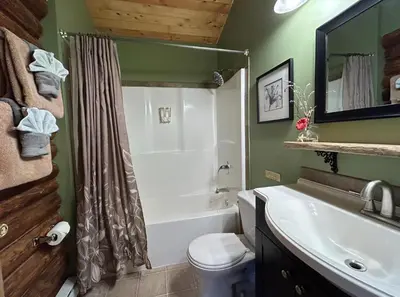 a bathroom with a tub and a toilet and a sink at Morning Star Cabin in Nelson