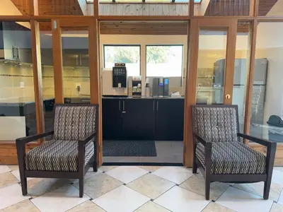 two chairs sitting in a room with a kitchen at Sunshine Lodge Inn in Gibsons