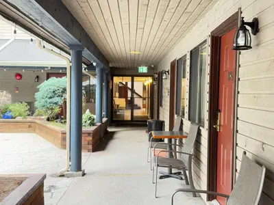 a patio with chairs and a table on a building at Sunshine Lodge Inn in Gibsons