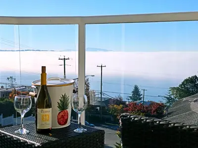 a bottle of wine and two glasses on a table at Star of the Sea guest house in White Rock