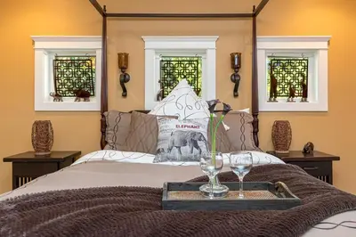a bed with a tray with wine glasses on it at Shawnigan Suite B & B in Shawnigan Lake