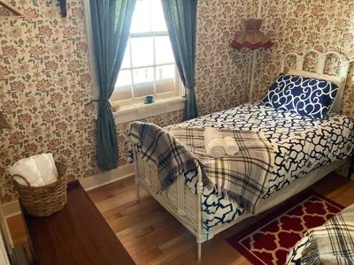 a small bedroom with a bed and a window at St. George Hotel in Barkerville