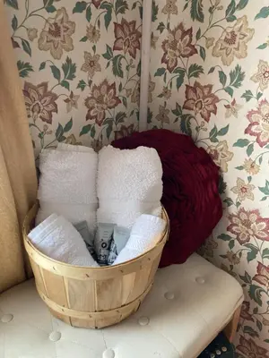 a basket of towels sitting on a bench in a room at St. George Hotel in Barkerville