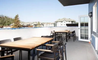 a patio with tables and chairs on a balcony at Pomeroy Hotel Fort McMurray in Fort McMurray