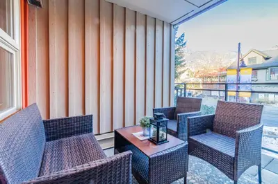 a patio with wicker chairs and a table at Lake Placid Lodge by Elevate Vacations in Whistler
