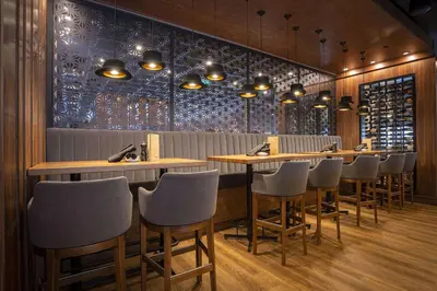 a restaurant with a row of tables and chairs at Sandman Signature Sherwood Park Hotel in Sherwood Park