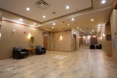 a lobby with chairs and a stage in a building at Days Inn & Suites by Wyndham Edmonton Airport in Leduc
