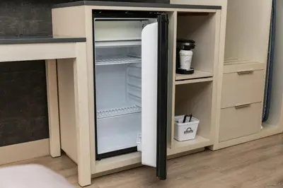 an empty refrigerator with its door open in a kitchen at Days Inn & Suites by Wyndham Edmonton Airport in Leduc