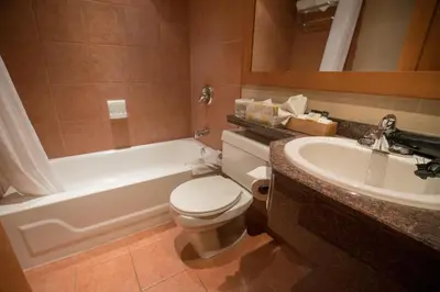 a bathroom with a tub and a toilet and a sink at The Hidden Ridge Resort in Banff