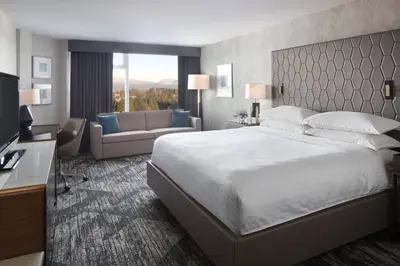 a hotel room with a large bed and a couch at Sheraton Vancouver Guildford Hotel in Surrey