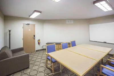 a conference room with a table and chairs and a whiteboard at Comfort Inn West in Edmonton