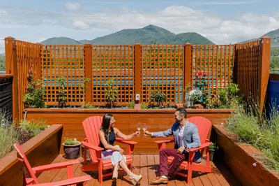 a man and woman sitting at a table on a patio at Pluvio restaurant and rooms in Ucluelet