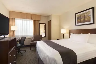 a hotel room with a bed and a desk at Travelodge by Wyndham Edmonton South in Edmonton