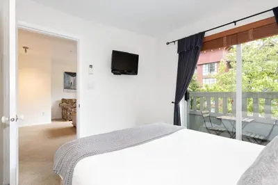 a bedroom with a bed and a large window at Bear Lodge (Town Plaza) in Whistler