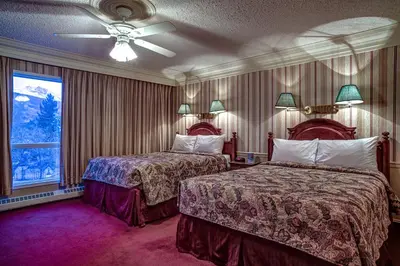 a hotel room with two beds and a window at Athabasca Hotel in Jasper