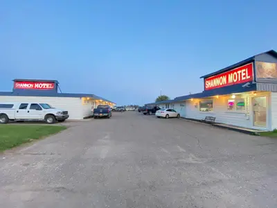 a parking lot with cars parked in front of buildings at Shannon Motel in Fort Nelson