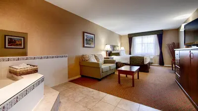 a hotel room with a bed and a couch at Best Western Plus Osoyoos Hotel & Suites in Osoyoos