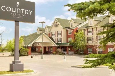 a sign in a parking lot in front of a building at Country Inn & Suites by Radisson, Calgary-Northeast in Calgary