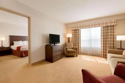 a hotel room with a bed and a television at Country Inn & Suites by Radisson, Calgary-Northeast in Calgary