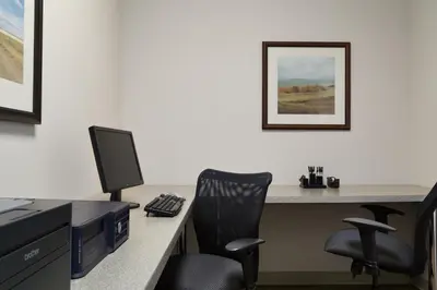 an office with a desk with a computer and two chairs at Country Inn & Suites by Radisson, Calgary-Northeast in Calgary