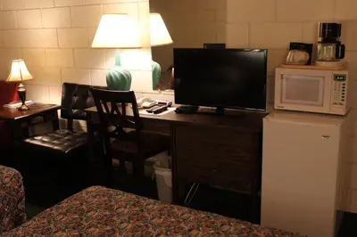 a hotel room with a desk with a television and a microwave at Best Continental Motel in Hope