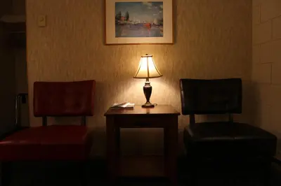 a lamp sitting on a table next to two chairs at Best Continental Motel in Hope