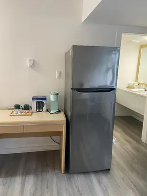 a stainless steel refrigerator in a kitchen next to a table at Slumber Lodge in Hope