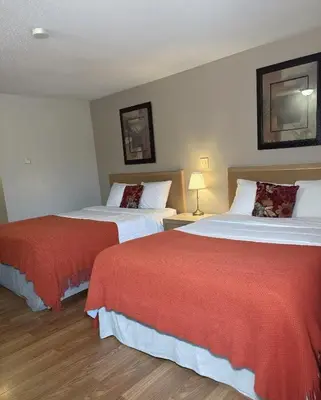 a hotel room with two beds with red sheets at Slumber Lodge in Hope