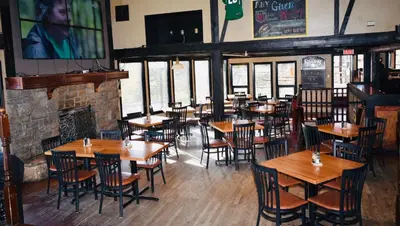 a restaurant with wooden tables and chairs and a fireplace at The Drake Inn in Canmore