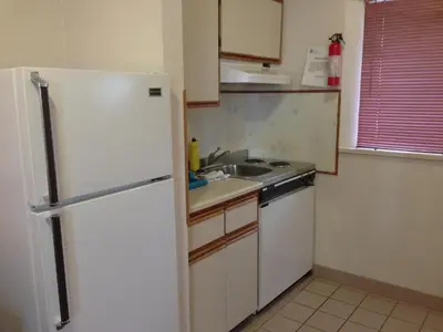 a kitchen with a white refrigerator and a sink at Rainbow Motor Inn in Chilliwack